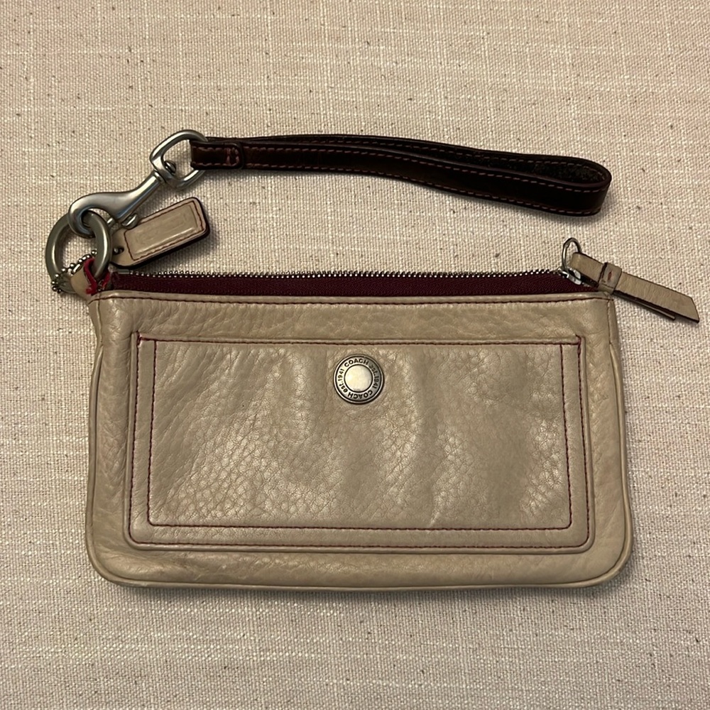 Dark cream, coach, leather wristlet with burgundy accents